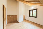Experience rustic charm in this beautifully appointed room featuring exposed wooden beams and warm, natural wood paneling.