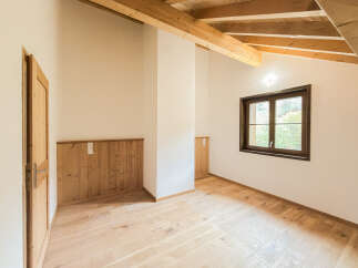 Experience rustic charm in this beautifully appointed room featuring exposed wooden beams and warm, natural wood paneling.