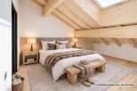 Experience ultimate comfort in this beautifully appointed bedroom, featuring a plush king-sized bed adorned with luxurious faux fur throws.