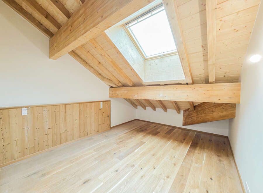 Experience the charm of this attic space, featuring exposed wooden beams and a skylight that floods the room with natural light.
