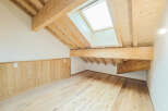 Experience the charm of this attic space, featuring exposed wooden beams and a skylight that floods the room with natural light.