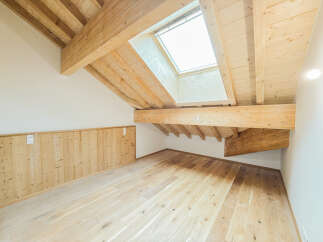 Experience the charm of this attic space, featuring exposed wooden beams and a skylight that floods the room with natural light.