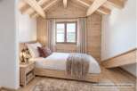 Experience cozy mountain living in this charming bedroom featuring a comfortable bed adorned with plush bedding and a decorative accent pillow.