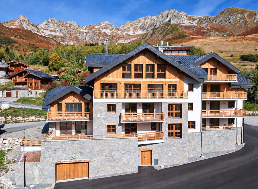 Experience luxury mountain living in this stunning multi-story chalet, featuring a stone base and warm wooden accents.