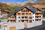 Experience luxury mountain living in this stunning multi-story chalet, featuring a stone base and warm wooden accents.