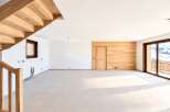 Experience modern living in this spacious, unfinished interior featuring a stunning wooden staircase and a feature wall of natural wood paneling.