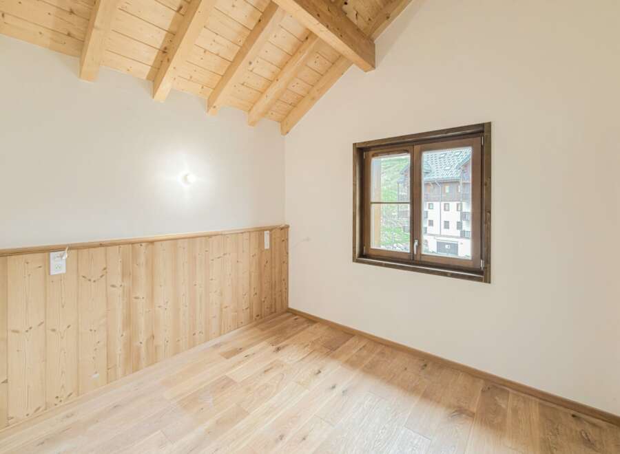 Experience the charm of this beautifully appointed room, featuring a vaulted wooden beam ceiling that adds warmth and character.
