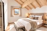 Experience cozy mountain living in this charming bedroom featuring a comfortable king-size bed adorned with plush pillows and a warm throw blanket.