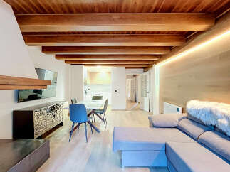 Experience modern living in this stunning open-plan space featuring exposed wooden beams and elegant wood-paneled walls.