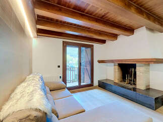 Experience rustic charm and modern comfort in this inviting living space, featuring exposed wooden beams and a cozy fireplace.