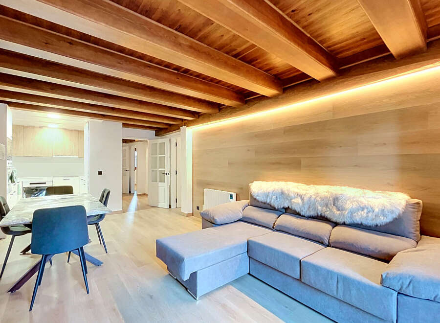 Experience modern living in this beautifully designed space featuring exposed wooden beams and warm, ambient lighting.
