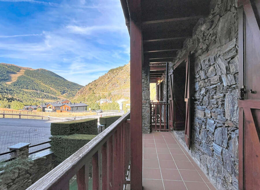 Experience breathtaking mountain views from this charming property, featuring a rustic stone facade and a spacious balcony perfect for enjoying the alpine scenery.