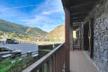 Experience breathtaking mountain views from this charming property, featuring a rustic stone exterior and a spacious balcony perfect for enjoying the alpine scenery.