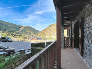 Experience breathtaking mountain views from this charming property, featuring a rustic stone exterior and a spacious balcony perfect for enjoying the alpine scenery.