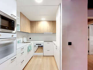 Discover this modern and functional kitchen, featuring sleek white cabinetry and a complementary wood-grain upper cabinet set.