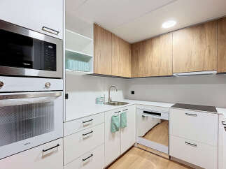 Discover this modern and functional kitchen, featuring sleek white cabinetry complemented by warm wood-grain upper cabinets.