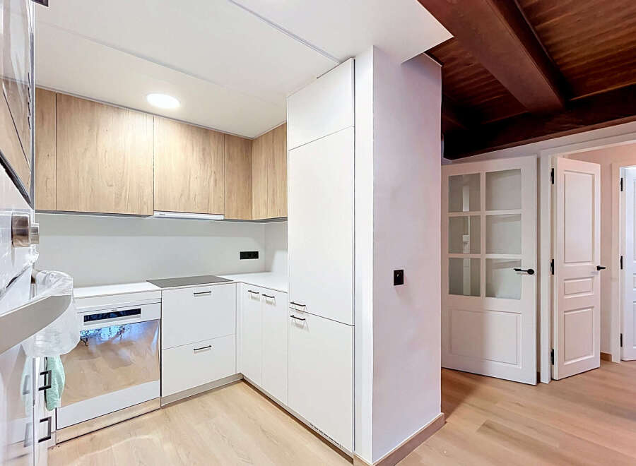 Discover this modern kitchen featuring sleek white cabinetry complemented by warm wood accents.