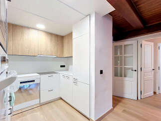 Discover this modern kitchen featuring sleek white cabinetry complemented by warm wood accents.
