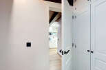 Step into a modern and inviting hallway featuring sleek white doors with elegant black hardware.