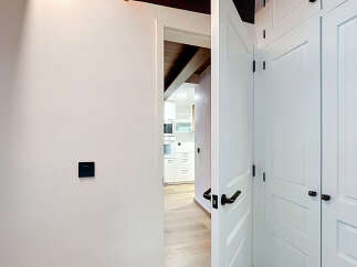 Step into a modern and inviting hallway featuring sleek white doors with elegant black hardware.