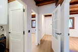 Step into this beautifully renovated hallway, featuring elegant white doors and exposed wooden beams that add rustic charm.