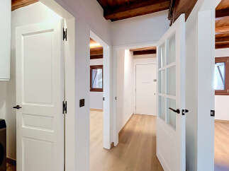 Step into this beautifully renovated hallway, featuring elegant white doors and exposed wooden beams that add rustic charm.
