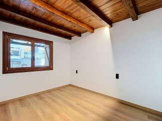 Experience rustic charm in this beautifully renovated room featuring exposed wooden beams and a warm, inviting atmosphere.