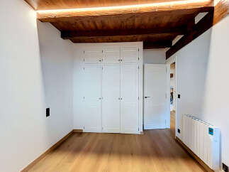 Discover this charming room featuring a built-in white wardrobe with multiple doors, perfect for ample storage.