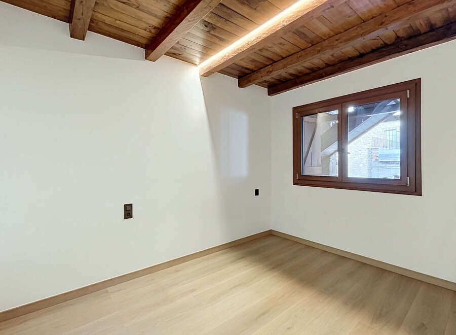 Experience rustic charm and modern comfort in this beautifully appointed room, featuring exposed wooden beams and a warm, inviting atmosphere.