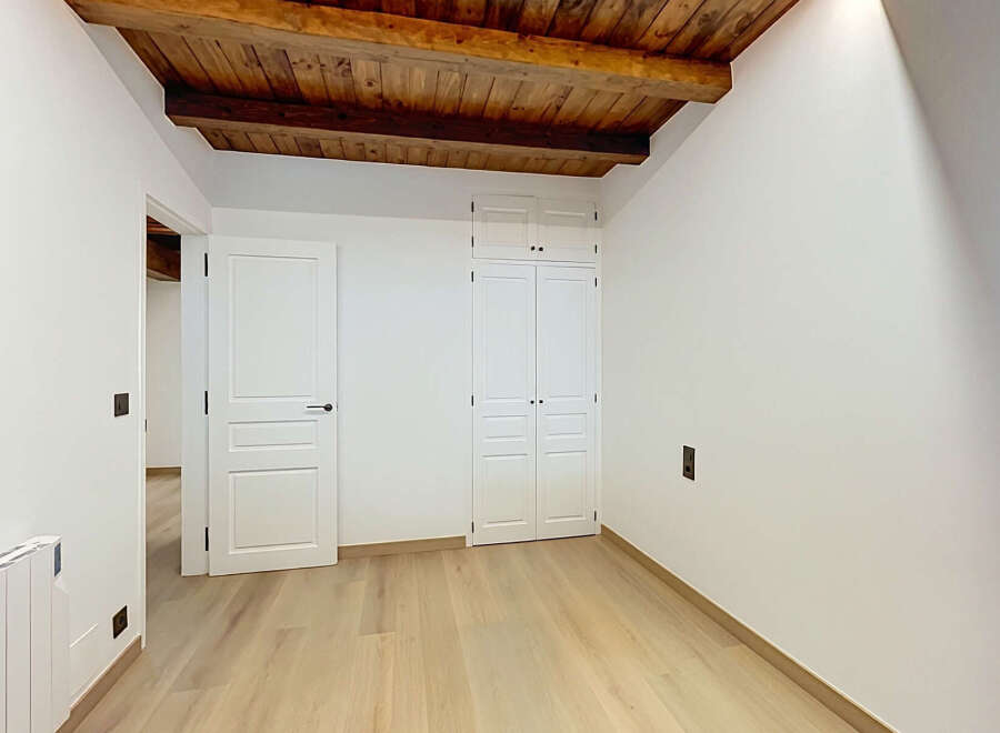 Discover this charming room featuring exposed wooden beams and a rustic wooden ceiling, adding warmth and character.