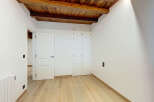 Discover this charming room featuring exposed wooden beams and a rustic wooden ceiling, adding warmth and character.