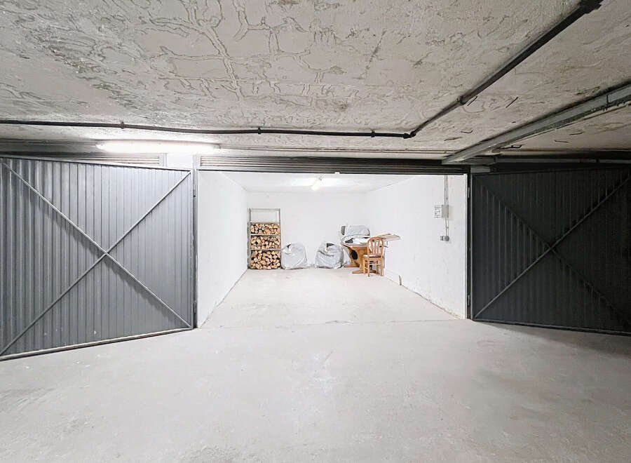 Discover this spacious garage with two large metal doors, offering ample storage and parking.
