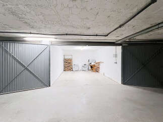 Discover this spacious garage with two large metal doors, offering ample storage and parking.
