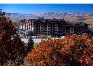 Experience luxury mountain living in this stunning lodge-style resort, nestled amidst vibrant autumn foliage and rolling hills.