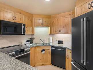 Discover this charming kitchen featuring sleek black appliances, including a modern microwave and a spacious refrigerator.