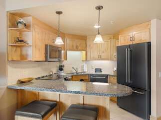 This charming kitchen features light wood cabinetry and granite countertops, offering a warm and inviting atmosphere.