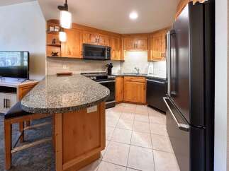 This spacious kitchen features warm wood cabinetry and a large granite-topped island, perfect for meal prep and casual dining.