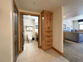 Step into this charming property featuring a well-appointed bathroom with a toilet and ample towel storage, conveniently located near a spacious living area.