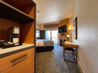 Experience comfort and convenience in this well-appointed hotel room, featuring a Keurig coffee maker and a cozy seating area.