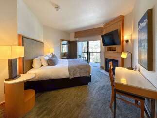 Experience comfort and convenience in this well-appointed hotel room, featuring a plush king-sized bed and a cozy seating area.