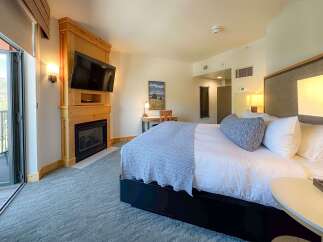 Experience ultimate comfort in this beautifully appointed hotel room, featuring a cozy fireplace and a large flat-screen TV for your entertainment.