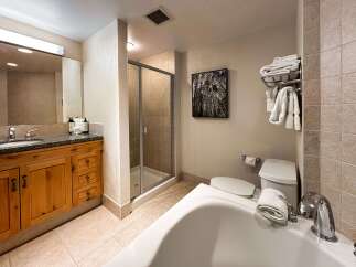 Experience luxury in this spacious bathroom featuring a deep soaking tub and a separate glass-enclosed shower.