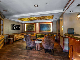 Experience rustic elegance in this inviting lounge area, featuring plush velvet and leather seating arrangements perfect for relaxation.