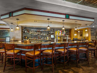 Step into this inviting bar area, featuring a polished concrete countertop and rich wooden accents.