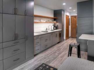 Discover modern living in this sleek kitchen featuring dark grey cabinetry and a convenient stovetop.
