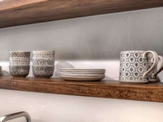 Showcasing a beautifully styled kitchen shelf, this image highlights a collection of ceramic bowls and mugs with intricate patterns, perfect for adding a touch of artisanal charm to your home.