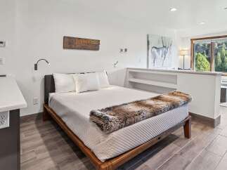 Experience comfort and style in this beautifully appointed bedroom, featuring a plush bed adorned with a luxurious faux fur throw.