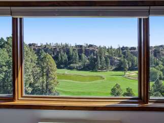 Experience breathtaking views from this stunning property overlooking a pristine golf course and lush natural landscape.