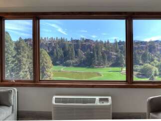 Enjoy breathtaking views of a lush golf course and rolling hills from this stunning property.