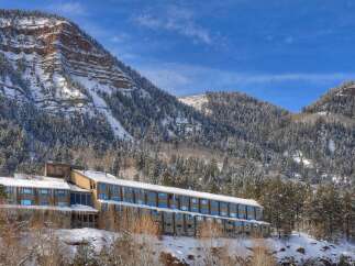 Experience the ultimate mountain retreat with this stunning hotel nestled against a majestic snow-covered peak.